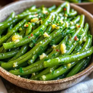To make Air Fryer Garlic Butter Green Beans, gather these simple ingredients: - 1 pound fresh green beans, trimmed - 4 tablespoons unsalted butter, melted - 4 cloves garlic, minced - 1 teaspoon lemon zest - 1 teaspoon salt - ½ teaspoon black pepper - ½ teaspoon red pepper flakes (optional) - 1 tablespoon fresh parsley, chopped (for garnish) These ingredients create a vibrant dish full of flavor. Fresh green beans give crunch and color. Unsalted butter adds richness, while minced garlic brings strong taste. Lemon zest adds brightness and freshness. The salt and pepper balance the flavors. If you want a little heat, try adding red pepper flakes. The fresh parsley not only adds color but also a fresh finish. Feel free to adjust the ingredient amounts to suit your taste. Cooking should be fun and personal! Preheat your air fryer to 380°F (190°C) for about 5 minutes. Preheating is key. It helps the green beans cook evenly. If you skip this step, the beans may not crisp well. In a large bowl, combine the following: - 1 pound fresh green beans, trimmed - 4 tablespoons unsalted butter, melted - 4 cloves garlic, minced - 1 teaspoon lemon zest - 1 teaspoon salt - ½ teaspoon black pepper - ½ teaspoon red pepper flakes (optional) Mix these ingredients well. Toss the green beans to ensure they are evenly coated. This step is vital for flavor. If you don’t coat them well, some beans will taste bland. Pour the green beans into the air fryer basket in a single layer. You may need to work in batches, depending on your air fryer’s size. Air fry the beans for 8-10 minutes. Shake the basket halfway through. This helps them cook evenly. Look for visual cues to check doneness. The beans should be tender yet crisp. If they are still too firm for your taste, cook them for another minute or two. After cooking, transfer the beans to a serving dish and garnish with fresh parsley. Enjoy your tasty side dish! To get the best bite from your green beans, adjust the cooking time. If you like them crisp, air fry for 8 minutes. For a softer bean, go for 10 minutes. Remember to shake the basket halfway through. This helps all the beans cook evenly. A quick shake can make a big difference. You can change the garlic or butter in this dish. Try using olive oil instead of butter for a lighter taste. If you want a kick, add a pinch of smoked paprika or cumin. Fresh herbs like thyme or dill can bring new life to the dish. Feel free to mix and match! If your green beans are overcooked, they can become mushy. Keep an eye on them during cooking. If you burn the garlic, it can taste bitter. To avoid this, add minced garlic halfway through the cooking time. This way, you can enjoy all the great garlic flavor without the burnt taste. {{image_2}} You can change up the recipe with different veggies. Try asparagus or Brussels sprouts for a twist. Both work well with garlic butter. They will add new flavors and textures to your meal. Incorporating nuts or seeds can enhance the dish too. Think about adding toasted almonds or sunflower seeds. They add a satisfying crunch and a nutty flavor that pairs nicely with the green beans. Experiment with various seasonings to keep things fun. Try adding a sprinkle of Italian herbs or a dash of smoked paprika. These can give the dish a unique taste. You could also play with different citrus zest, like lime or orange, for a fresh twist. Adding cheese can take the dish to a new level. Grated Parmesan or crumbled feta can offer a creamy, salty flavor. Just sprinkle it on right before serving for a tasty finish. Using an air fryer is quick and easy, but you can also use a traditional oven. Bake the green beans at 400°F for about 15-20 minutes. This method works well but may take longer. If you prefer stovetop cooking, sauté the green beans in a large pan. Use medium heat and cook for about 6-8 minutes. This method gives you a nice char and keeps the beans crisp. To keep your air fryer garlic butter green beans fresh, store them in the fridge. Place them in an airtight container. This prevents moisture and keeps them tasty. They will stay good for about 3 to 4 days. If you want to freeze them, first let them cool down. Then, put them in a freezer-safe bag. Squeeze out the air before sealing. You can freeze these green beans for up to 3 months. Just remember to label the bag with the date. When it's time to enjoy your leftovers, reheating is key. The best way to reheat green beans is in the air fryer. Set it to 350°F (175°C) and heat for about 5 minutes. This keeps them crispy and tasty. You can also use a skillet on medium heat. Just add a small amount of butter or oil to help with crispness. Stir them often to heat evenly. In the fridge, your green beans last about 3 to 4 days. In the freezer, they can stay fresh for 3 months. Look for signs of spoilage. If they smell off or have a slimy texture, it's time to toss them. Fresh green beans should be bright green and firm. Yes, you can use frozen green beans. They may need extra cooking time. Start by air frying them for 10-12 minutes. Check for doneness after 10 minutes. Frozen beans might not get as crispy as fresh. If you want a crisper texture, thaw them first. Pat dry to remove excess moisture. These green beans pair well with many dishes. Try serving them with grilled chicken or steak. They also go great with roasted salmon. For a vegetarian option, serve them with quinoa or pasta. You can also add them to a salad for extra crunch. The bright garlic flavor complements many meals. To make this dish vegan, swap out the butter for vegan butter or olive oil. Use the same amount for a rich taste. You can also add a splash of lemon juice for extra zest. Ensure the garlic and spices remain the same for flavor. Fresh parsley can still be used for garnish. In this article, we explored how to make air fryer garlic butter green beans. We covered the ingredients, from fresh green beans to optional spices. The step-by-step guide helped you preheat the air fryer and prepare the garlic butter mix. Tips to achieve the perfect crunch were included, along with variations and storage info. Remember, cooking is flexible, so feel free to try new flavors. Enjoy your tasty green beans as a side dish or snack!
