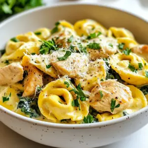 - 12 oz cheese tortellini - 1 lb boneless, skinless chicken breasts - 2 tablespoons olive oil - 3 cloves garlic, minced - 1 cup heavy cream - 1 cup grated Parmesan cheese - 1 cup fresh spinach, chopped - Fresh parsley, chopped {{ingredient_image_1}} To start, grab a large pot and fill it with water. Add a few pinches of salt to the water. Turn the heat to high and wait until it boils. Once the water bubbles, add in the cheese tortellini. Cook the tortellini for about 3-5 minutes. You want it to be al dente, which means it should still have a little bite. When done, drain the tortellini and set it aside. Next, take a large skillet and put it on medium heat. Pour in 2 tablespoons of olive oil and let it heat up. Once hot, add the diced chicken. Season it with salt, pepper, and 1 teaspoon of Italian seasoning. Cook the chicken for about 6-8 minutes. It should turn golden brown and be fully cooked. This step gives the chicken a nice flavor. Now, reduce the heat to low. Pour in 1 cup of heavy cream, stirring well to mix it with the chicken. Gradually add 1 cup of grated Parmesan cheese, stirring continuously. You want the cheese to melt fully and create a creamy sauce. Keep stirring until you reach a smooth consistency. It’s time to bring everything together! Add the cooked tortellini and 1 cup of chopped fresh spinach to the skillet. Toss everything gently so the spinach wilts and the tortellini gets coated in the creamy sauce. Make sure every piece is covered well for the best flavor. To avoid overcooking tortellini, follow these steps. First, bring a large pot of salted water to a boil. This adds flavor. Once boiling, add the cheese tortellini. Watch the time closely. Cook them for about 3-5 minutes. Check for doneness a minute early. You want them al dente, firm but not hard. Drain them right away to stop the cooking. Rinse briefly under cold water if needed. This helps them stay perfect for your creamy dish. To boost the flavor of your dish, consider adding some spices. A pinch of red pepper flakes can add some heat. Try fresh basil or oregano for a garden taste. You can also mix in some lemon zest for brightness. These flavors pair well with the creamy sauce. Feel free to experiment. Each spice can change the dish in fun ways! When serving Creamy Parmesan Chicken Tortellini, think about the best sides. A fresh green salad works well. Use a light vinaigrette to balance the creaminess. You might also serve it with garlic bread. The crunchy bread complements the soft tortellini. For a heartier meal, add steamed vegetables. Broccoli or green beans are great choices. They add color and nutrients. Enjoy your meal with family and friends! Pro Tips Cook Tortellini Al Dente: Ensure you cook the tortellini just until al dente for the best texture, as it will continue to cook slightly when added to the sauce. Use Fresh Garlic: Freshly minced garlic will provide a more aromatic flavor than pre-minced garlic, enhancing the overall taste of the dish. Adjust Creaminess: If you prefer a lighter sauce, you can substitute half of the heavy cream with chicken broth, which will still keep the dish flavorful. Season Gradually: Taste the dish as you go and adjust the seasoning gradually. This ensures you achieve the perfect balance of flavors without over-seasoning. {{image_2}} You can change up the recipe with different pasta types. If you can’t find cheese tortellini, try using ravioli or fettuccine. These options still hold the creamy sauce well. Just adjust the cooking time based on the pasta you choose. You might also want to swap proteins. Instead of chicken, use diced turkey or shrimp. Both options cook quickly and soak up the sauce nicely. For a vegetarian twist, use mushrooms or tofu. They add great texture and flavor to the dish. To make this dish lighter, use half-and-half instead of heavy cream. This change cuts down on calories but keeps a creamy texture. You can also use reduced-fat Parmesan cheese for less fat. If you need a dairy-free version, try coconut cream instead of heavy cream. It adds a unique flavor and creamy feel. Use nutritional yeast for a cheesy taste without dairy. Adding seasonal vegetables can enhance the recipe. In spring, toss in fresh asparagus or peas. Both add color and crunch. In summer, consider cherry tomatoes or zucchini. They bring a burst of freshness. In fall, you might add roasted butternut squash for a sweet touch. In winter, kale or Brussels sprouts can provide heartiness. These changes keep your dish exciting and vibrant all year round. To keep your Creamy Parmesan Chicken Tortellini fresh, store leftovers in an airtight container. Let the dish cool down to room temperature first. Refrigerate it within two hours after cooking. Properly stored, it will last for up to three days. Make sure to label containers with the date for easy tracking. To reheat the tortellini without losing its creaminess, use a skillet over low heat. Add a splash of milk or cream while warming. This keeps the sauce smooth and creamy. Stir gently to combine everything well. You can also use the microwave, but cover the bowl to prevent drying out. Heat in short intervals, stirring often. If you want to freeze this dish, first cool it completely. Use a freezer-safe container for storage. It’s best to freeze in individual portions for easy meals later. This dish can be frozen for up to three months. To thaw, place it in the fridge overnight before reheating. Avoid refreezing after thawing to maintain quality. To make this dish gluten-free, swap the cheese tortellini for gluten-free tortellini. You can find this option at most grocery stores. Check the label to ensure it fits your needs. If you cannot find gluten-free tortellini, you can use gluten-free pasta, like penne or fusilli. Cook it according to the package instructions. The rest of the recipe remains the same. Yes, you can prepare this dish in advance. Cook the tortellini and chicken as directed. Once you make the creamy sauce, allow it to cool. Store the chicken, tortellini, and sauce separately in the fridge. When ready to eat, reheat everything together in a skillet. Add a splash of cream if it seems thick. I recommend serving this dish with a simple green salad. A fresh Caesar salad pairs nicely, too. Garlic bread makes a tasty side that everyone loves. You can also add sautéed vegetables for extra nutrition. Consider steamed broccoli or roasted asparagus. These sides complement the creamy flavors well. This recipe covers all you need for Creamy Parmesan Chicken Tortellini. We explored key ingredients like cheese tortellini, chicken, and a rich cream sauce. I shared step-by-step instructions to make cooking easy and fun. You learned tips to enhance flavors and ways to adjust the dish for your diet. Storing and reheating leftovers was also explained for your convenience. Now, you're ready to impress at your next meal with this creamy delight. Enjoy the flavors and make it your own!